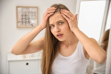 Photo of Young woman with hair loss problem indoors