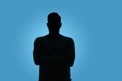 Silhouette of anonymous man on light blue background