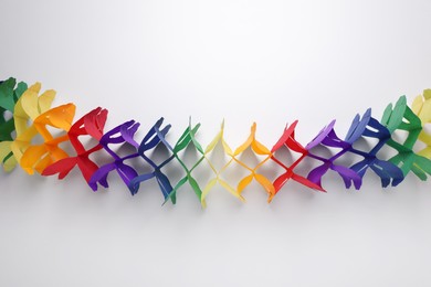 Photo of Rainbow paper garland on white background, top view. LGBT pride