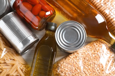 Different products on white wooden table, flat lay. Food donation