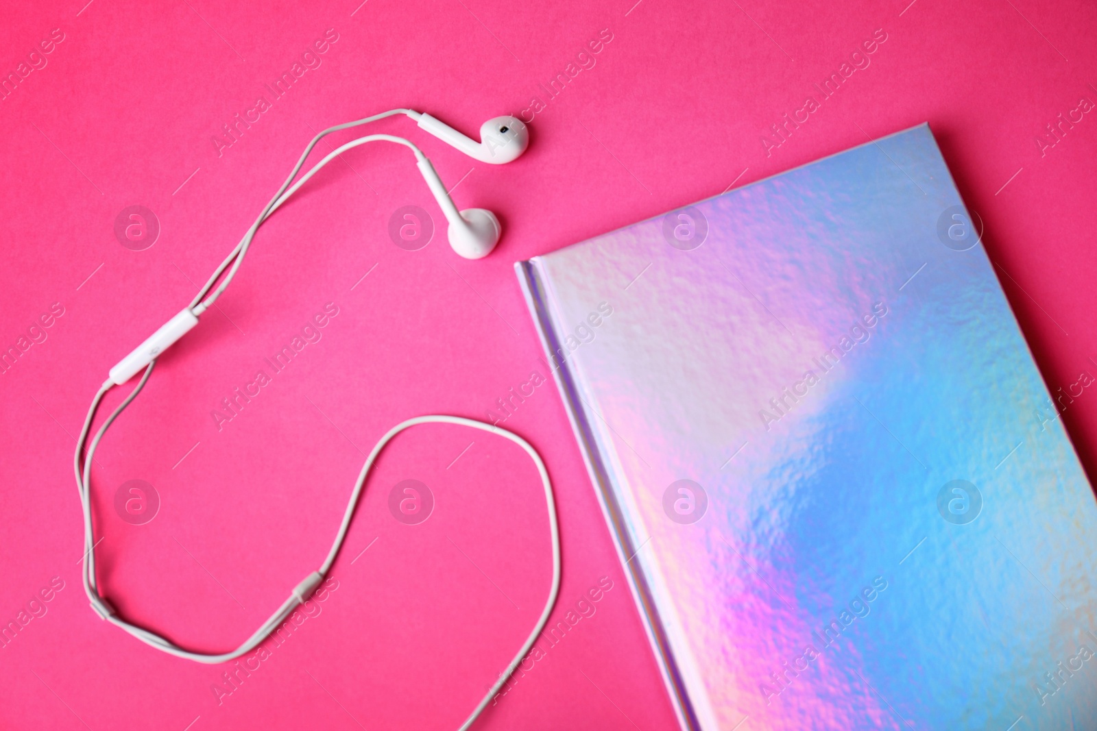 Photo of Stylish girl notebook and earphones on color background, closeup