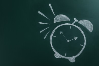 Alarm clock drawn on green chalkboard, space for text. School time