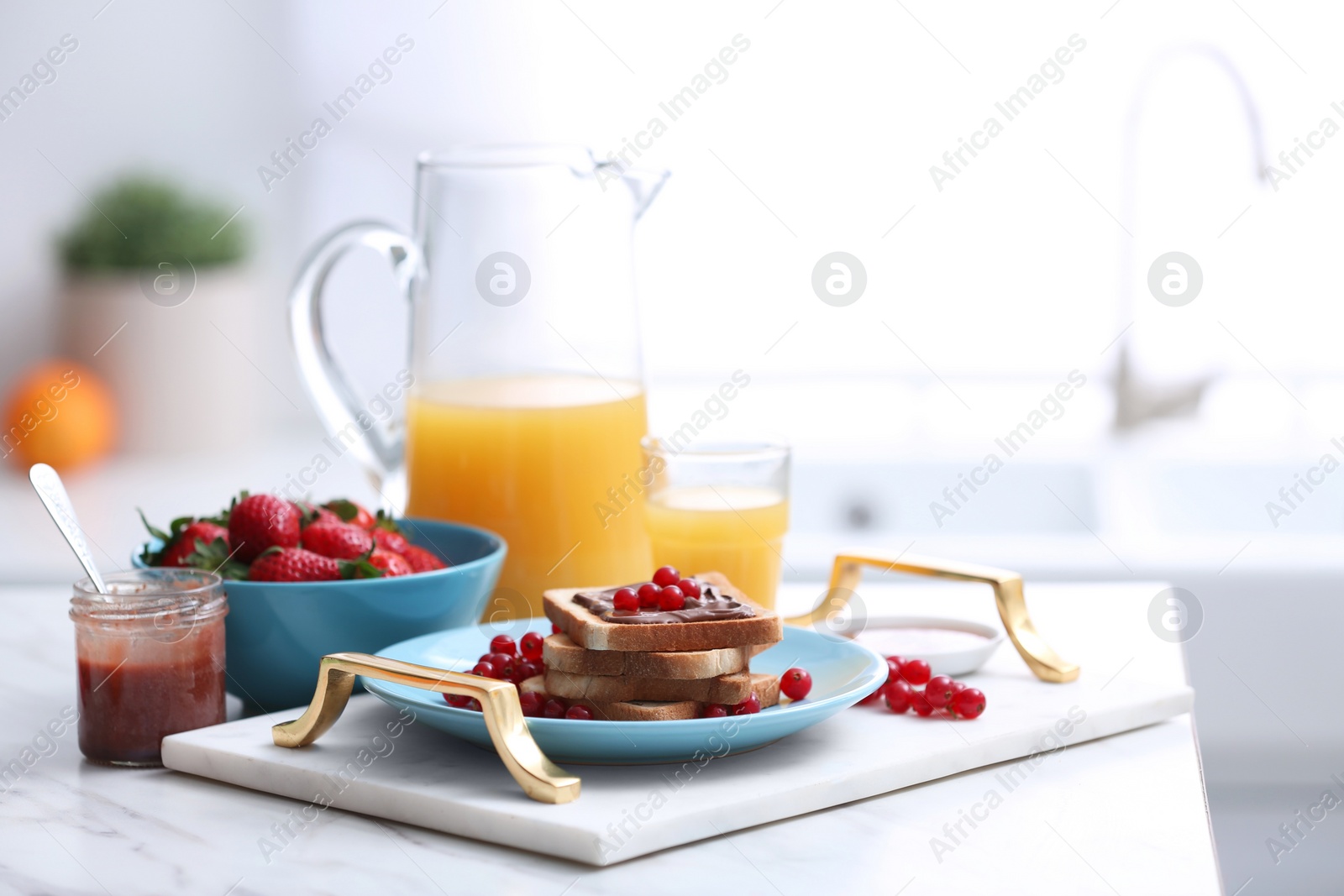 Photo of Toasted bread with chocolate spread and fresh cranberries on white marble table in kitchen