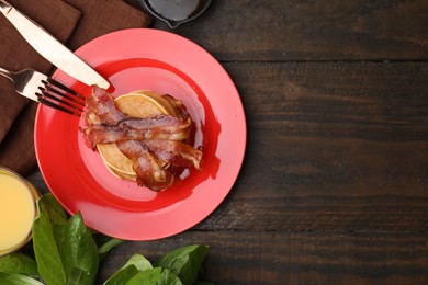 Delicious pancakes with bacon served on wooden table, flat lay. Space for text