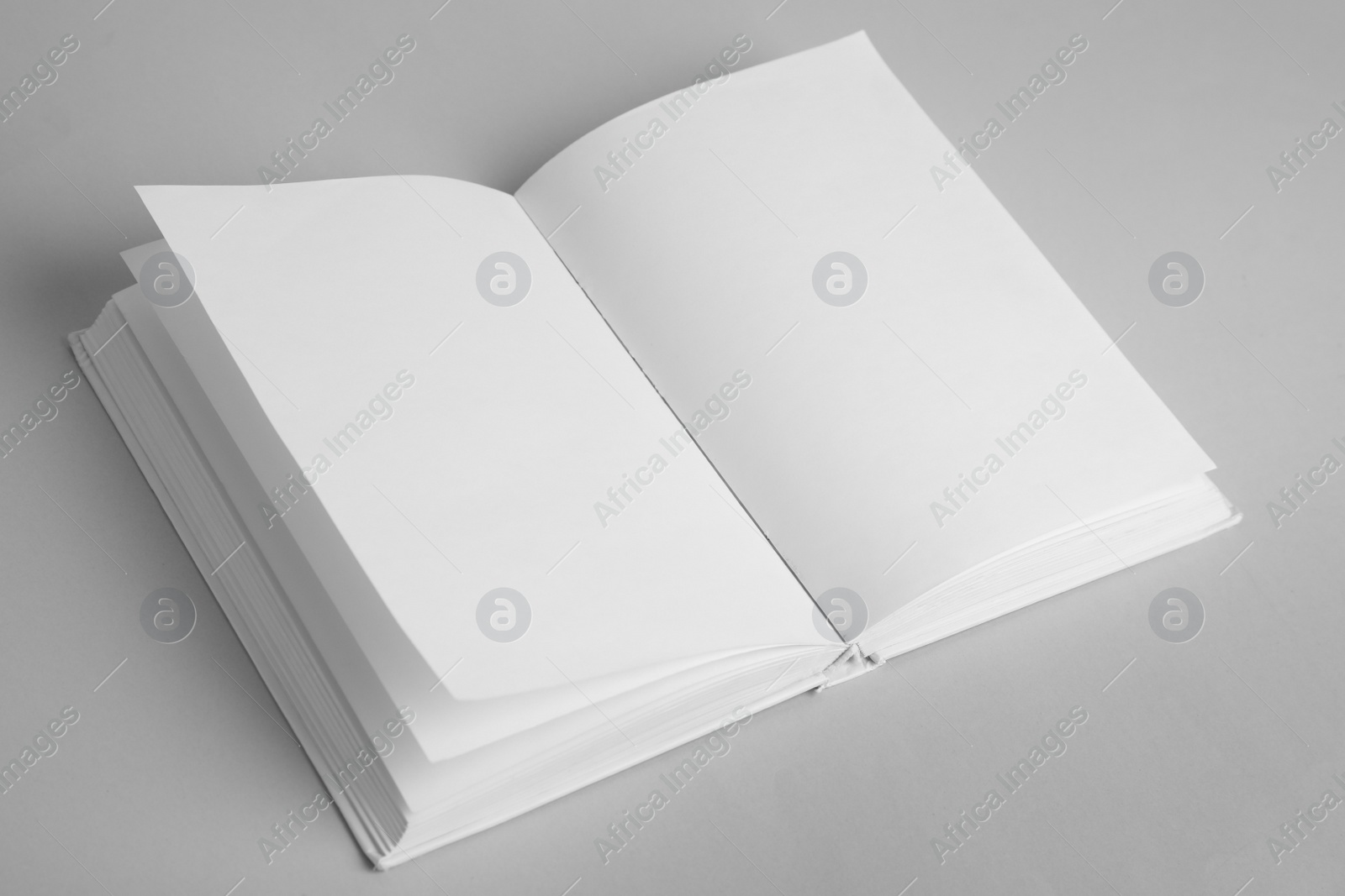 Photo of Open book with blank pages on grey background