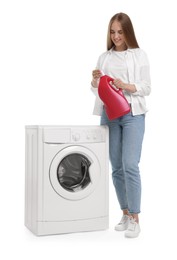 Beautiful young woman with detergent near washing machine on white background