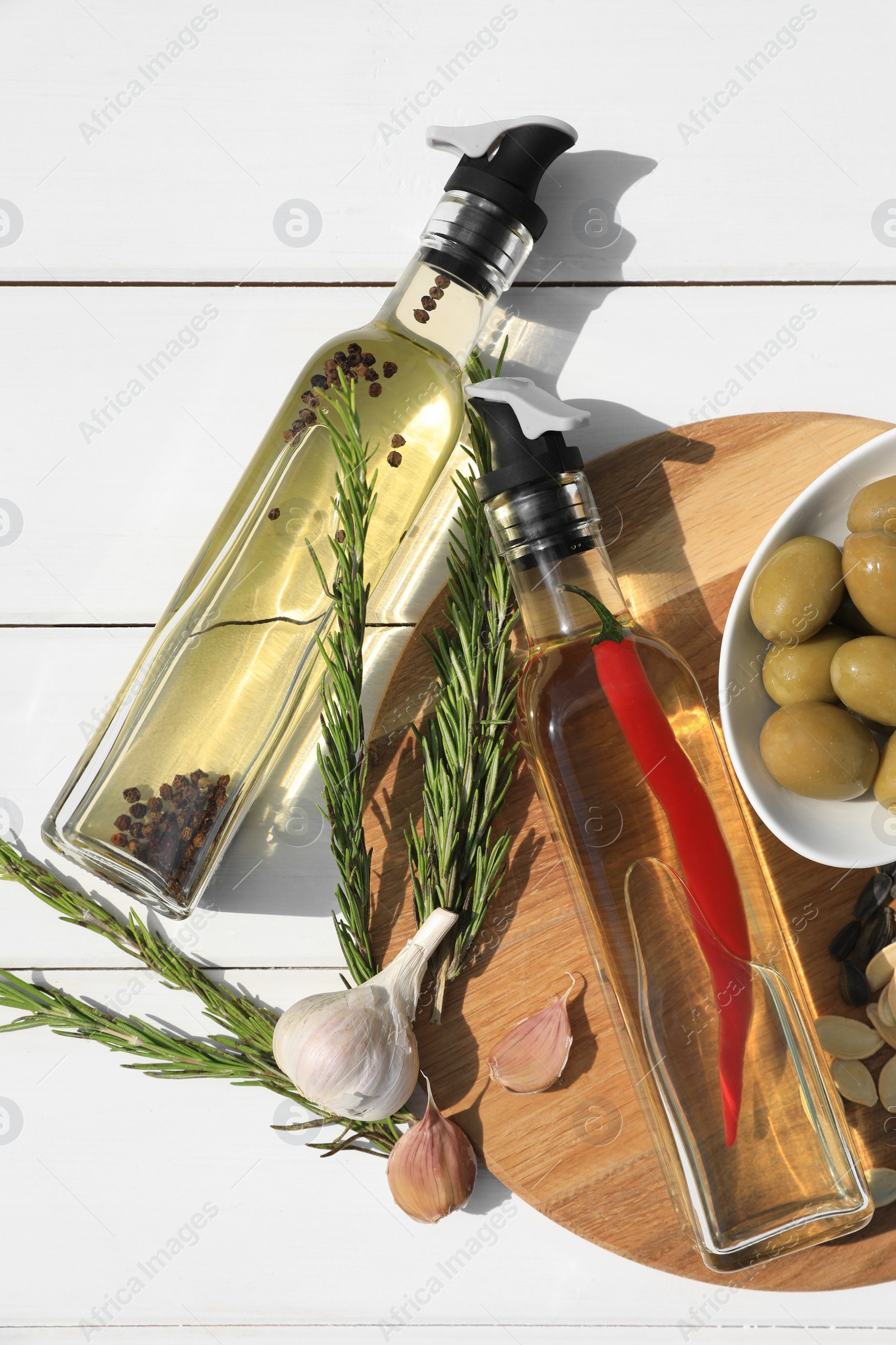 Photo of Different cooking oils and ingredients on white wooden table, flat lay