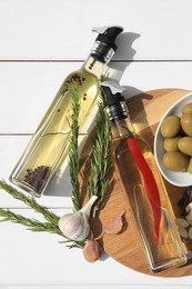 Different cooking oils and ingredients on white wooden table, flat lay