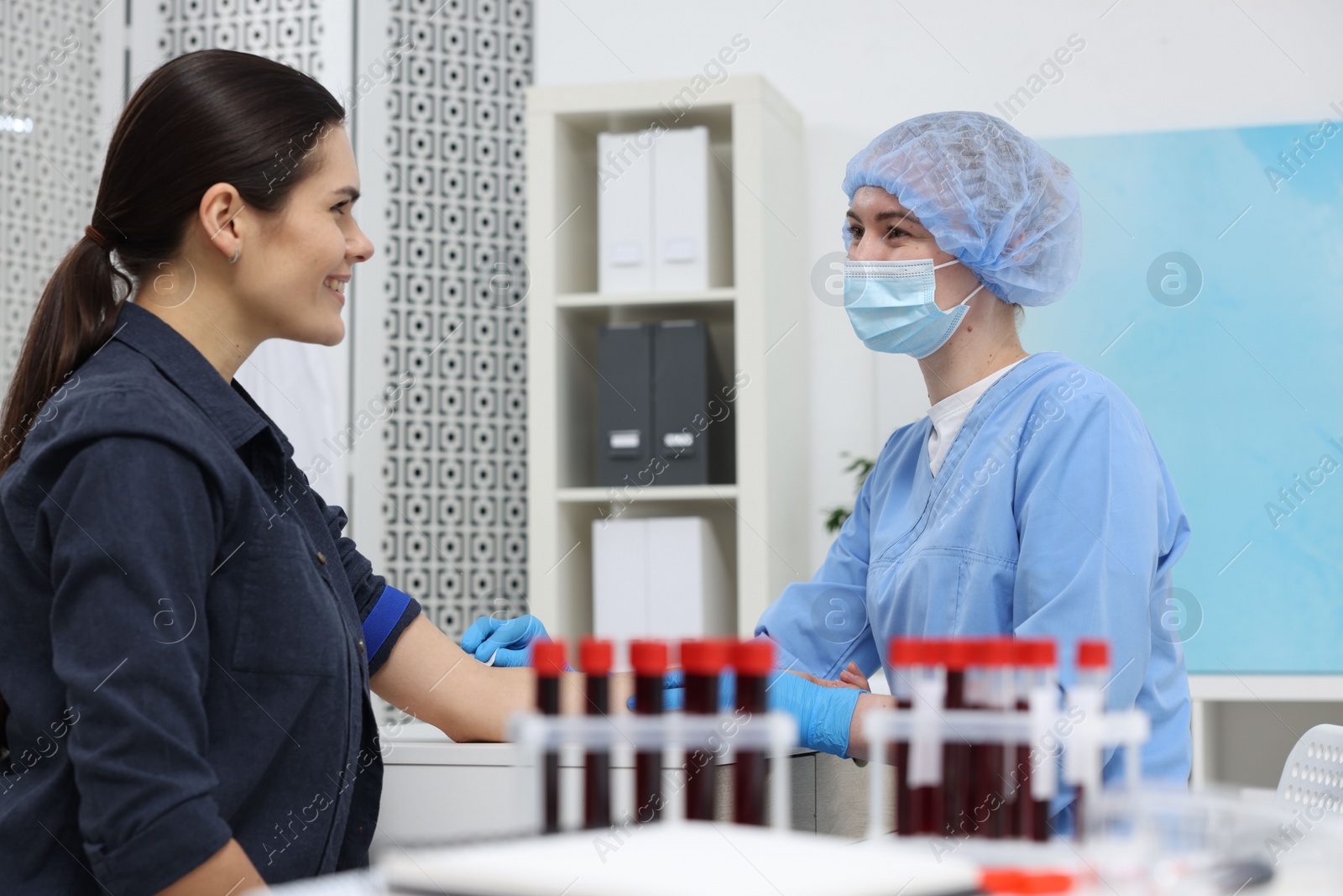 Photo of Laboratory testing. Doctor taking blood sample from patient at table in hospital