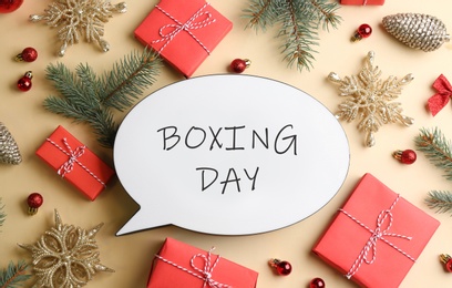 Photo of Speech bubble with phrase BOXING DAY and Christmas decorations on beige background, flat lay