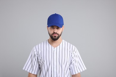 Man in stylish blue baseball cap on light grey background