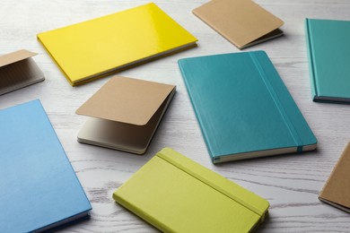 Different colorful planners on white wooden table