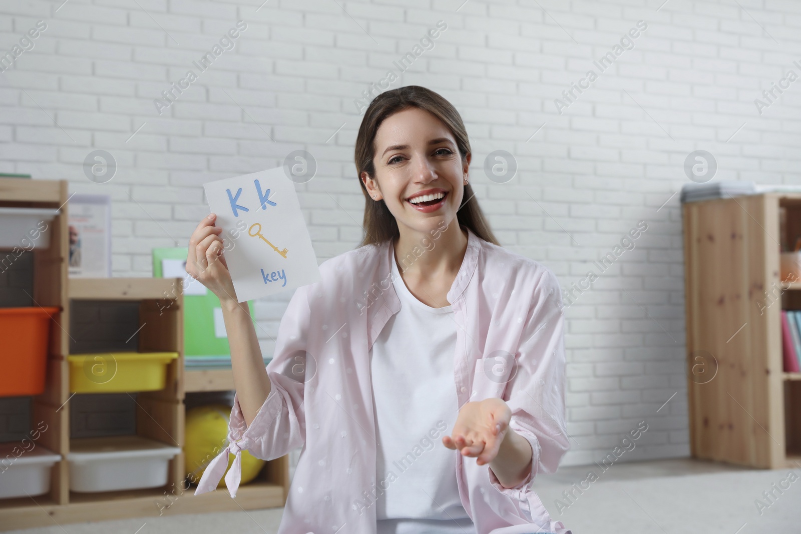 Photo of Happy female English teacher giving lesson in elementary school