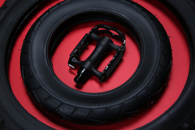 Bicycle tires and pedal on red background, closeup