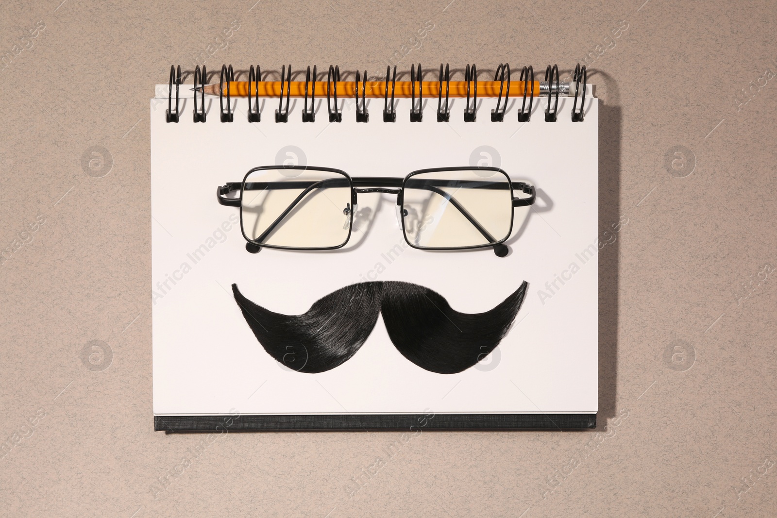 Photo of Flat lay composition with artificial moustache and glasses on light brown background