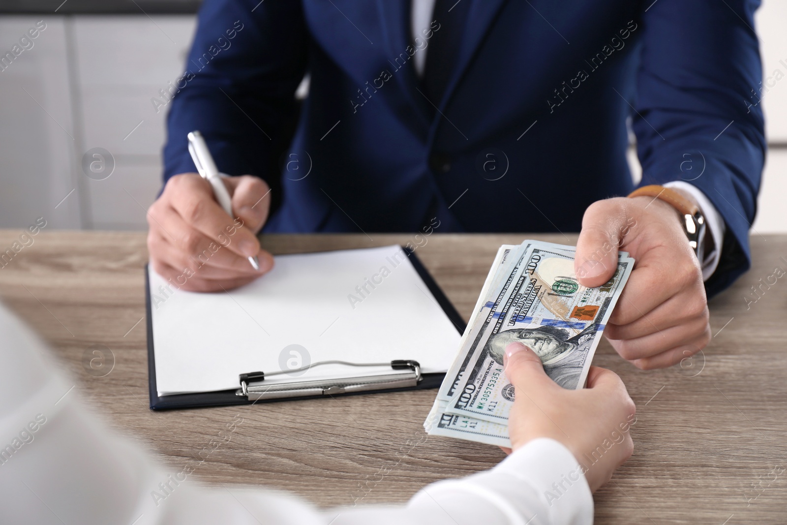 Photo of Woman giving bribe to man at table in office, closeup