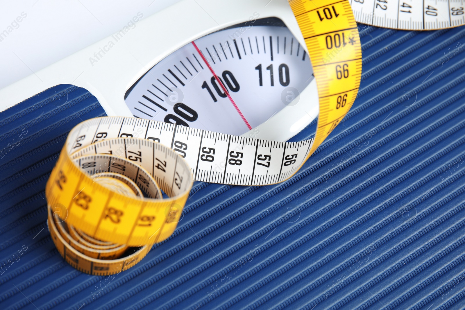 Photo of Scales with tape measure, closeup view. Diet and weight loss