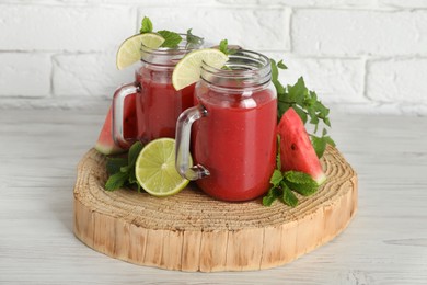 Tasty summer watermelon drink, limes and mint on white wooden table