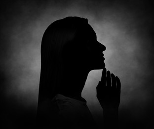 Image of Silhouette of woman in darkness. Portrait on black background