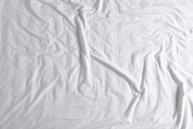 Photo of Crumpled white fabric as background, top view