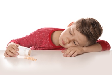 Photo of Little child with pills on white background. Danger of medicament intoxication