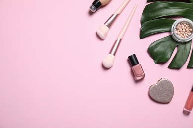 Photo of Makeup products and green leaf on pink background, flat lay. Space for text