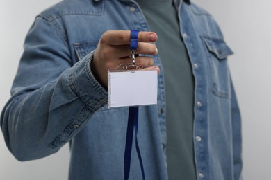 Man with blank badge on grey background, closeup