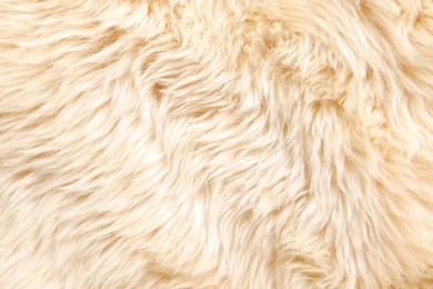 Photo of Texture of beige faux fur as background, top view