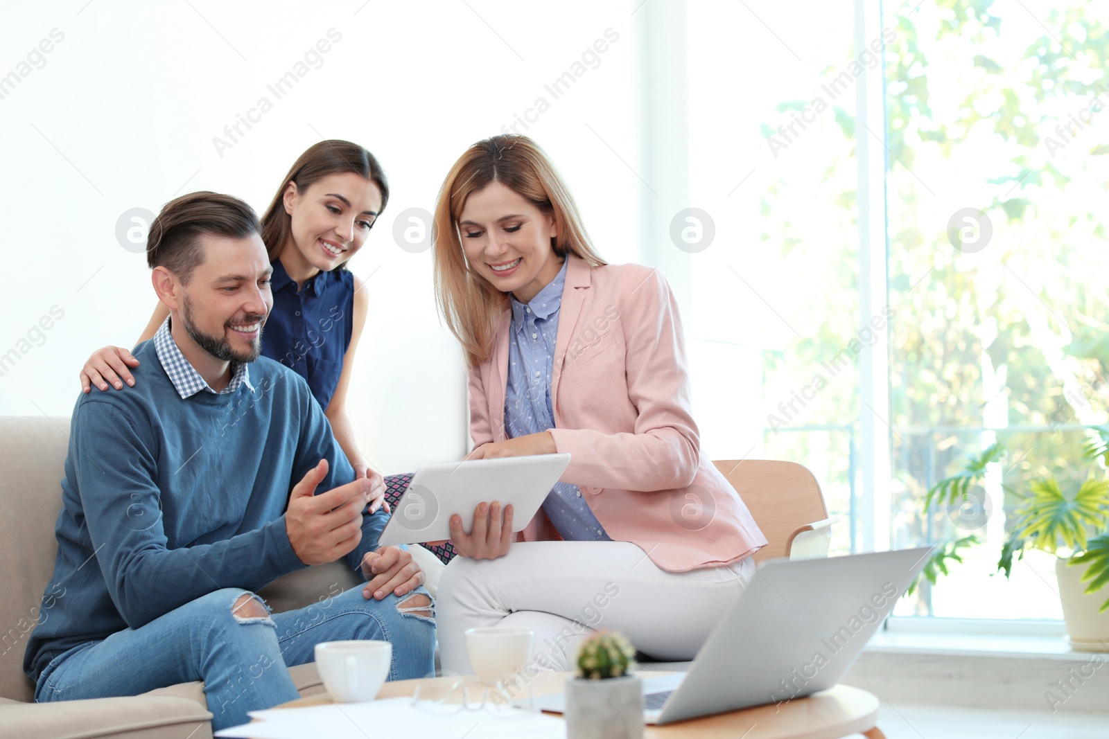 Photo of Female real estate agent working with couple in office