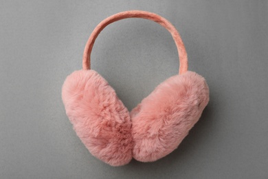 Stylish winter earmuffs on grey background, top view