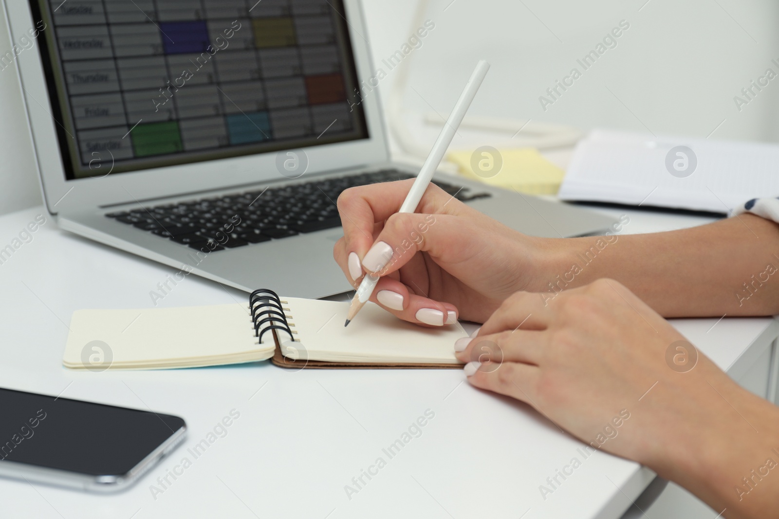 Photo of Woman planning her schedule with calendar app on laptop in office, closeup