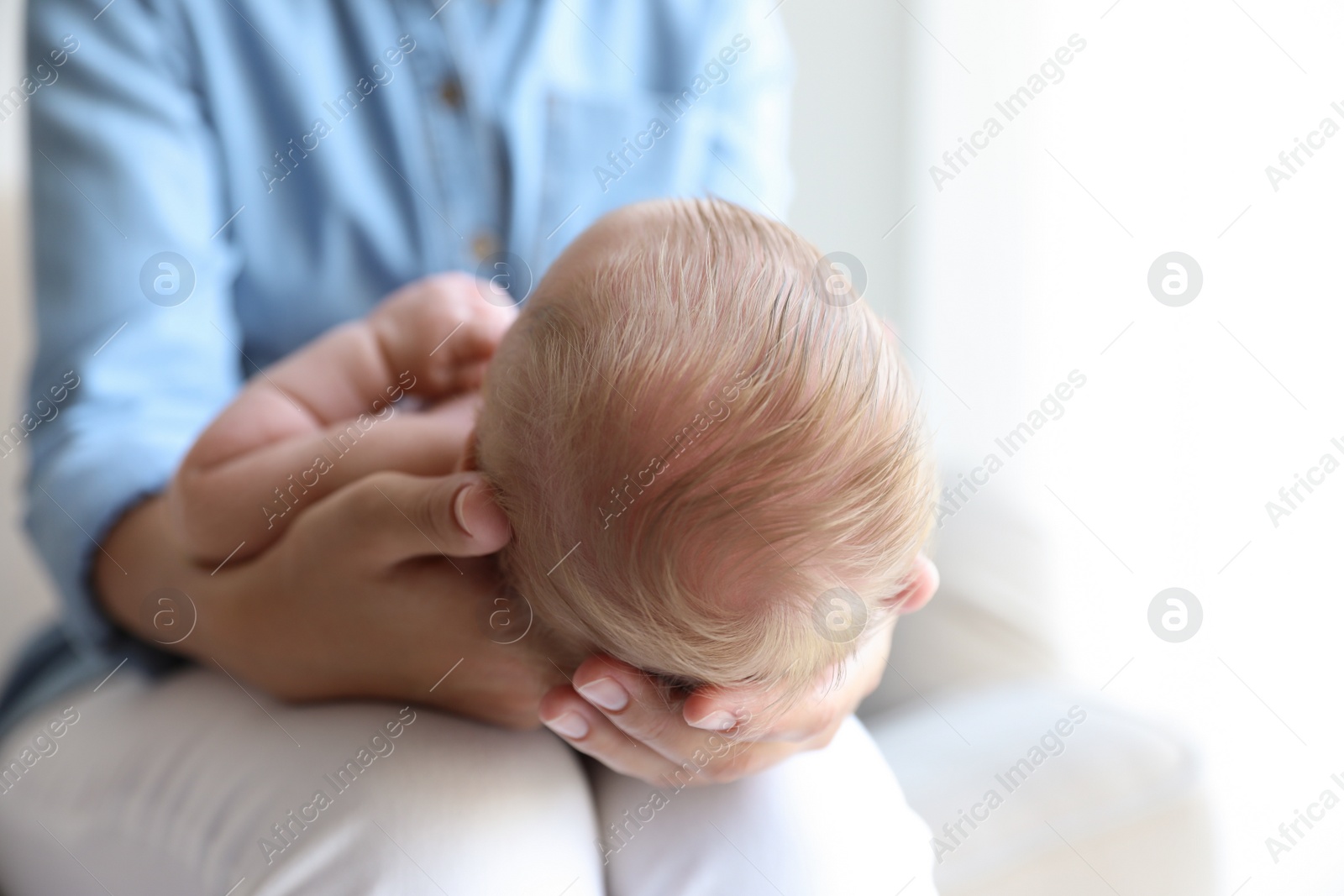 Photo of Mother holding her newborn baby at home, closeup