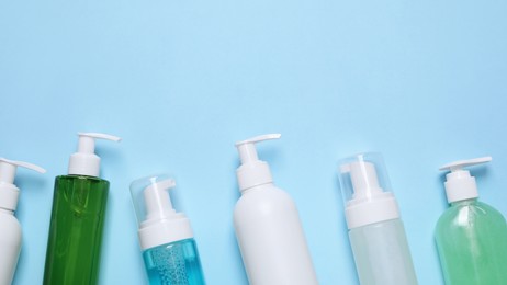 Photo of Different cleansers on light blue background, flat lay. Cosmetic product