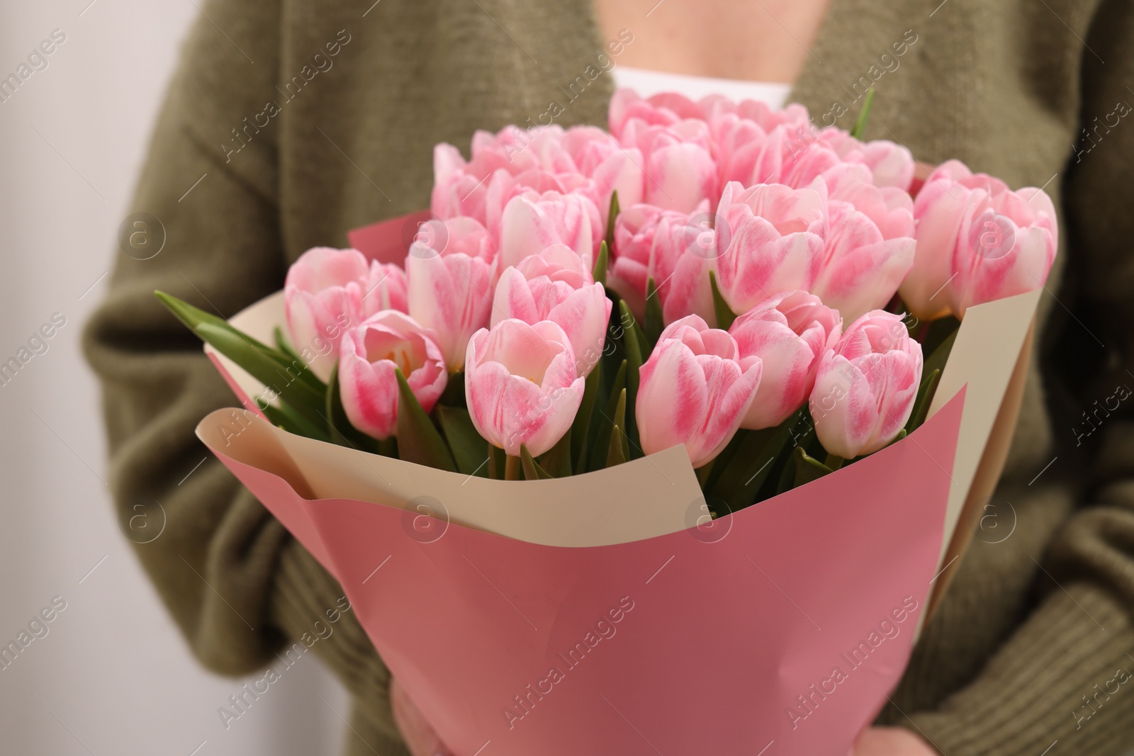 Photo of Woman with bouquet of beautiful fresh tulips on blurred background, closeup