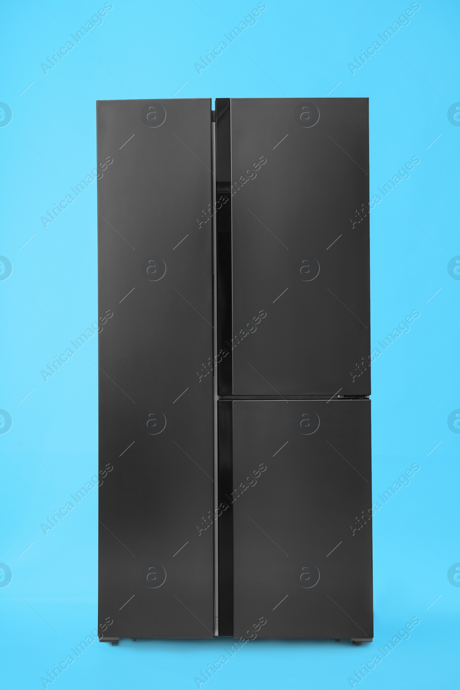 Photo of Modern stainless steel refrigerator on blue background