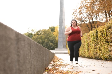 Photo of Beautiful overweight woman running in park. Fitness lifestyle