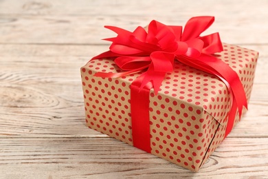 Elegant gift box with bow on wooden background