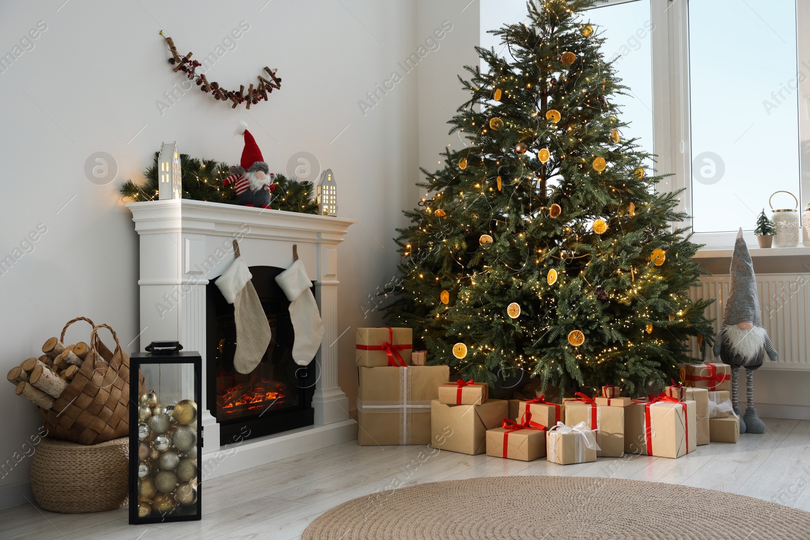 Photo of Many different gift boxes under Christmas tree and festive decor in living room