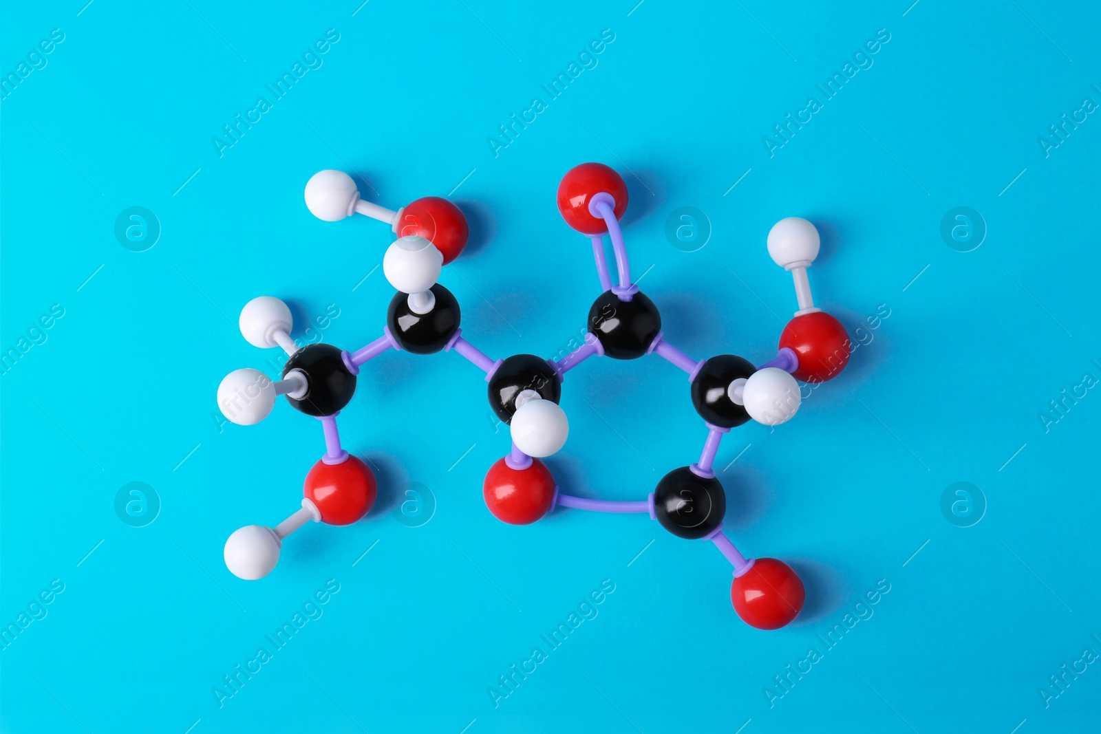 Photo of Molecule of vitamin C on light blue background, top view. Chemical model