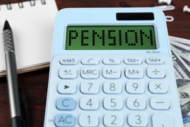 Image of Calculator with word Pension, money, pen and notebook on wooden table, closeup