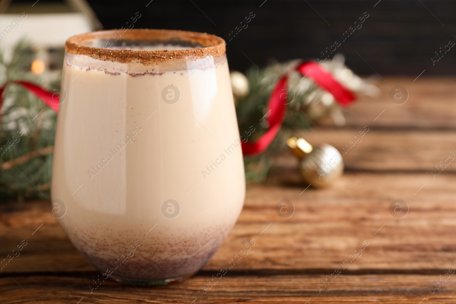 Photo of Delicious Christmas liqueur on wooden table, closeup. Space for text