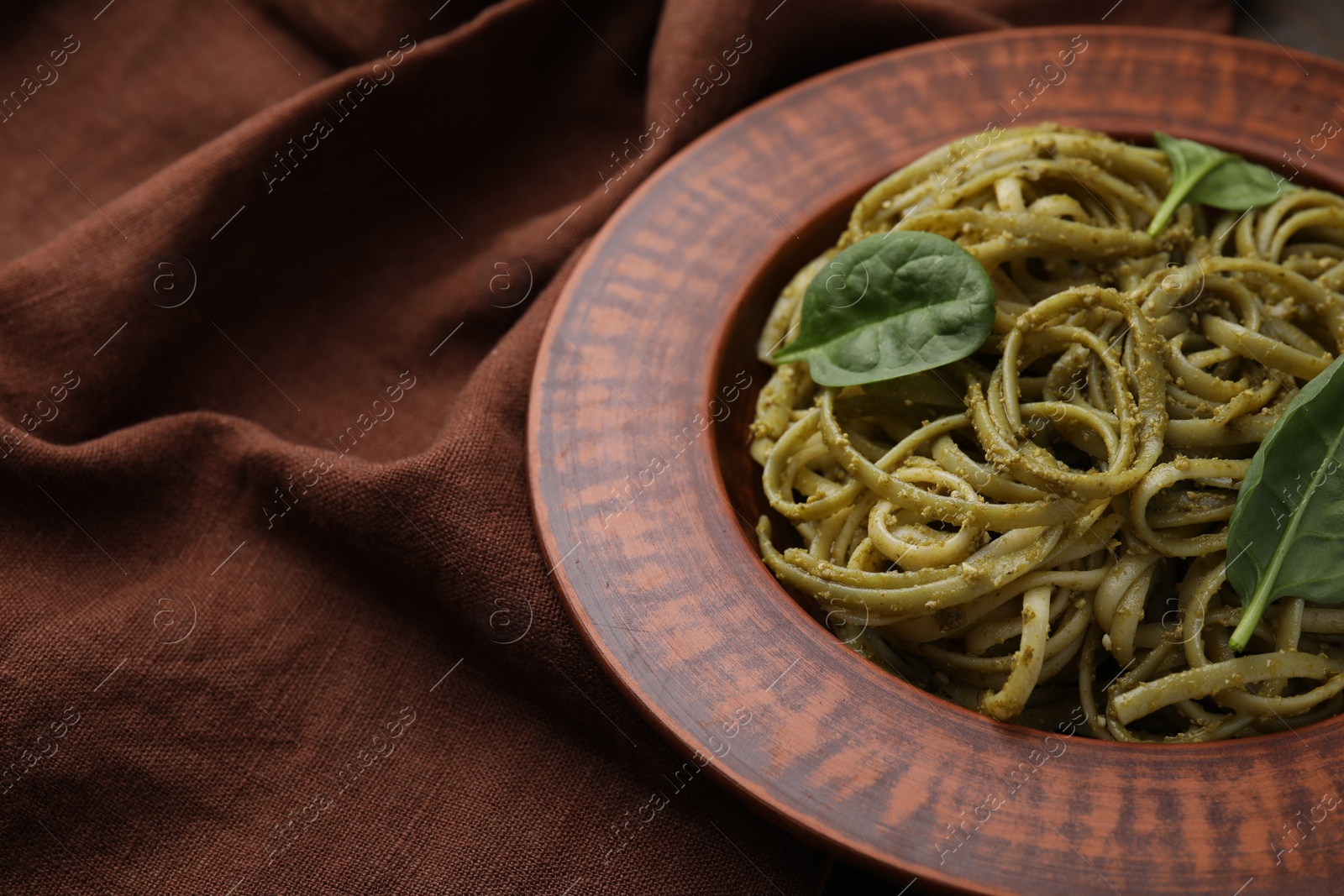 Photo of Tasty pasta with spinach on table, space for text