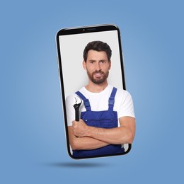 Image of Plumber looking out of smartphone on light blue background