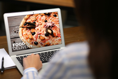 Image of Woman using laptop for online food order during quarantine, closeup. Delivery service