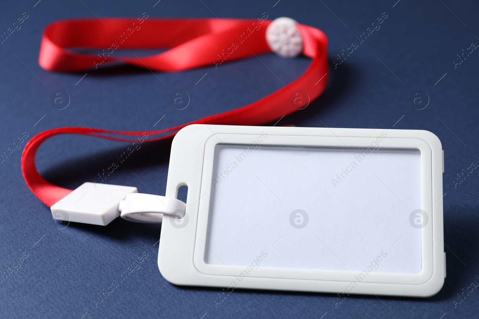 Photo of Blank badge with string on blue background, closeup