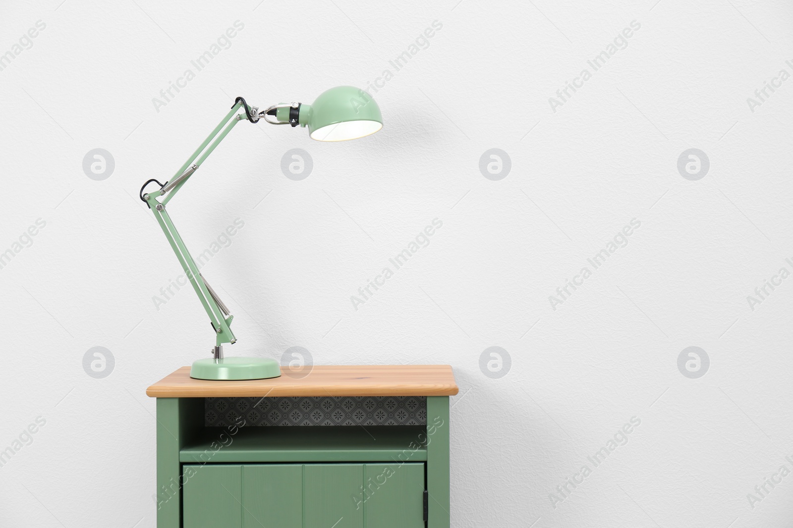 Photo of Stylish lamp on table against white background. Space for text