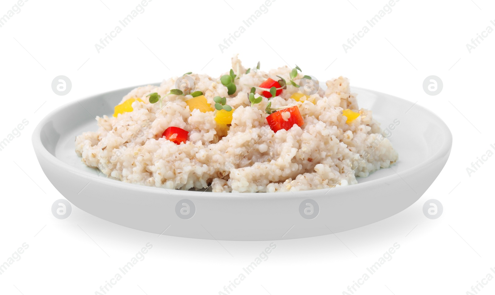Photo of Delicious barley porridge with vegetables and microgreens isolated on white