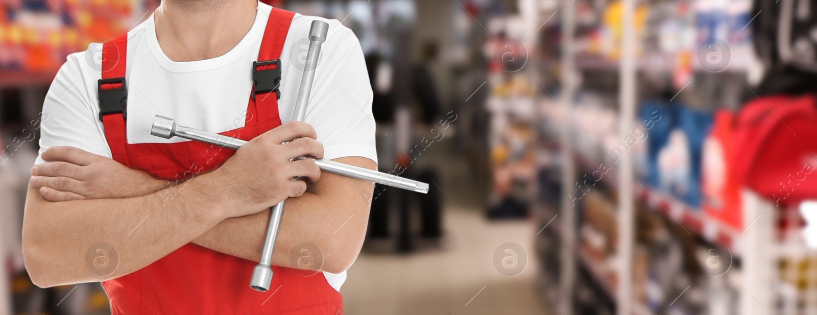 Image of Professional mechanic with lug wrench at tire shop, closeup. Banner design
