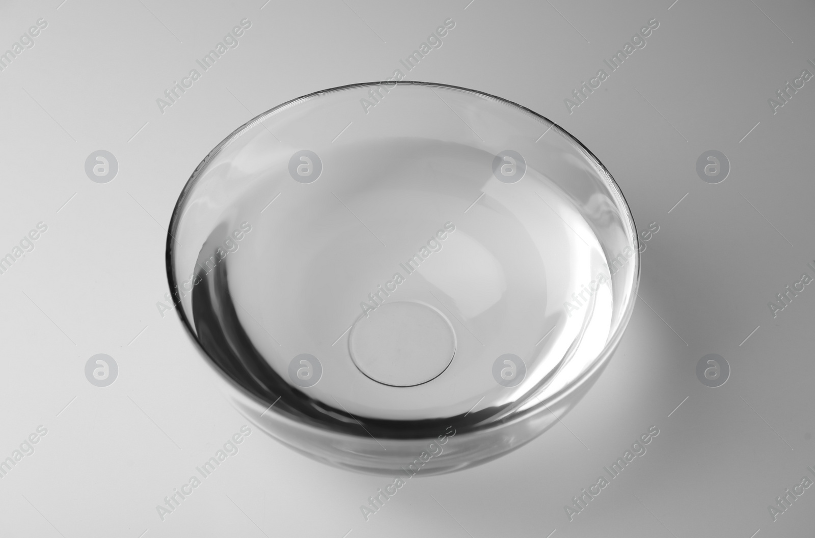 Photo of Glass bowl full of water on white background