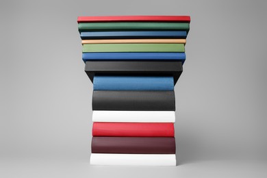 Photo of Stack of different hardcover books on light grey background